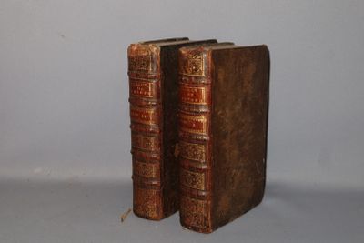 two old books sitting on top of each other on a table