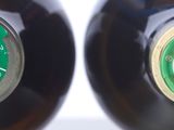 two bottles of beer sitting next to each other on a table