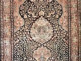 an antique persian rug with a floral design on a black ground