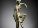 a bronze statue of a man in the form of a dancer