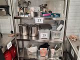 many pots and pans on the shelf in the kitchen