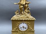 a gold clock with a statue on top of it