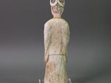 statue of a woman in a white dress with a mask on her head