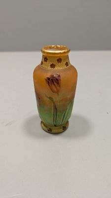 un petit vase posé sur une table, sur fond blanc