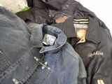 a pile of jackets and jackets sitting on a bed