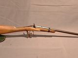 gros plan d'un fusil avec une poignée en bois sur fond blanc
