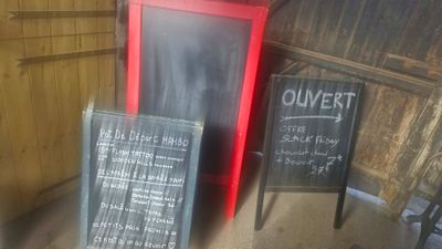 un tableau noir sur lequel est inscrit un menu, à côté d'un autre tableau noir
