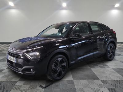 a black car is parked on a checkered floor in a garage