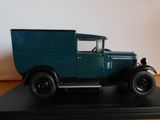 une maquette de camion bleu posée sur un socle noir