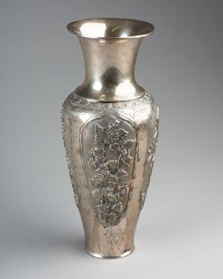 a silver vase that is sitting on a table
