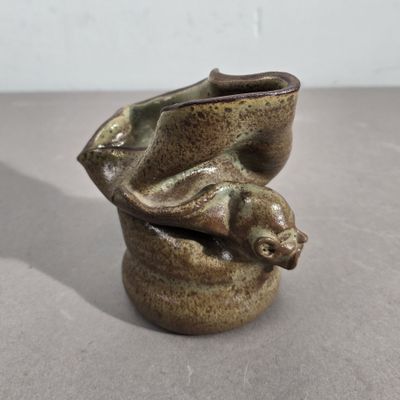 un petit vase dans lequel se trouve un petit animal