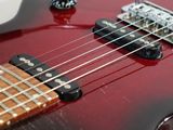 a close up of a red electric guitar on a white surface