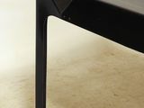 a black coffee table with a glass top on a beige floor