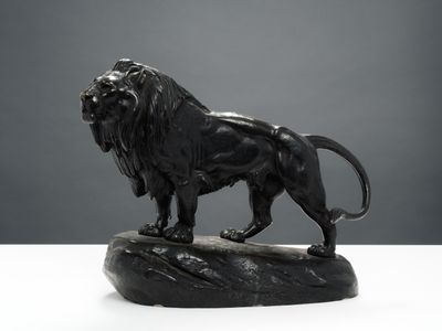 statue d'un lion debout sur un rocher, posée sur un fond blanc