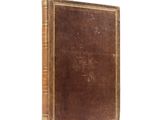 an old book sitting on top of a white surface next to a white wall