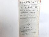 an old book sitting on top of a wooden table next to a white wall