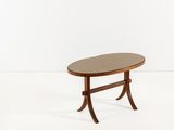 une table basse ovale avec un piètement en bois et des pieds courbés