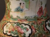 a vase with a painting on it sitting on a table