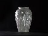 a glass vase sitting on a table with a black background