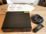 un lecteur DVD posé sur une table, à côté d'une télécommande