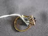 a gold ring with a blue stone on top of a white string