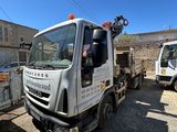 un camion blanc avec une grue à l'arrière