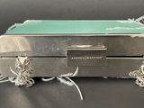 a silver suitcase with a green top and silver handles