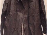leather jacket on a hanger on a bed with a white sheet