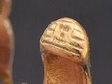 a small figurine of a man and a shoe on a table