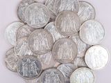 une pile de pièces d'argent posée sur une surface blanche