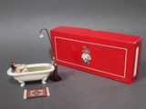 a toy bathtub with a doll in it next to a red box