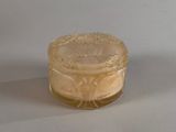 a small glass jar with a lid on a white surface