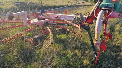 a tractor that is sitting in the grass with a plow attached to it