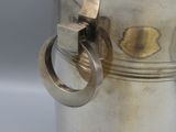 a silver vase with a ring handle on a table