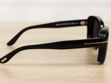 a pair of black sunglasses sitting on top of a wooden table