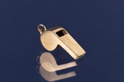 un sifflet doré sur un fond bleu avec un reflet