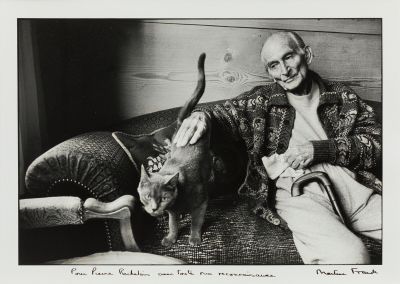 black and white photograph of a man sitting on a couch with a cat