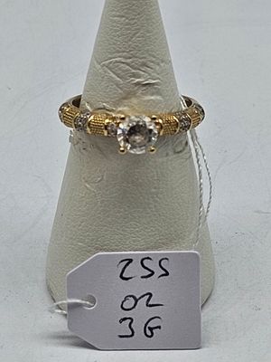 a gold ring with a diamond on top of a white cone