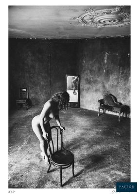photographie en noir et blanc d'une femme nue assise sur une chaise