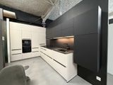 une cuisine en noir et blanc avec des placards blancs et une chaise grise