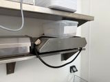 une étagère métallique sur laquelle sont posés un micro-ondes et un four à micro-ondes