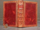 an old red leather book with a lock on top of it