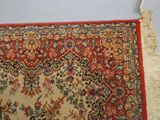 un tapis rouge à motifs floraux et franges