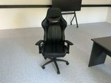 une chaise de bureau noire placée devant un bureau noir