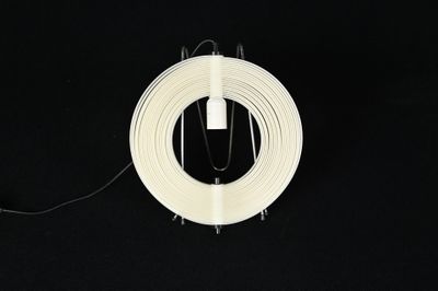 un rouleau de fil blanc posé sur une surface noire