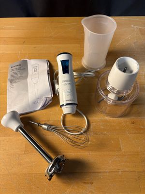 a wooden table with a blender, a measuring cup, and a blender on it