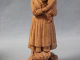 a statue of a woman holding a baby and a dog
