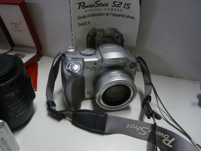a silver camera sitting on a table next to a camera