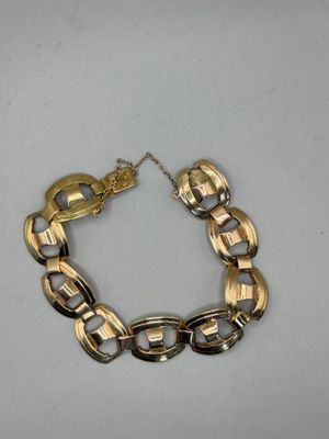 a close up of a gold chain bracelet on a white surface