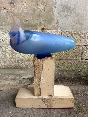 un objet bleu posé sur un bloc au sol